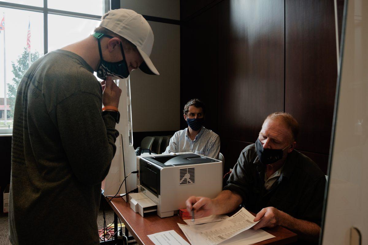 A poll worker explains to a voter how to correctly fill out their ballot at Howard Baker Jr. Center on Oct. 26, 2020.