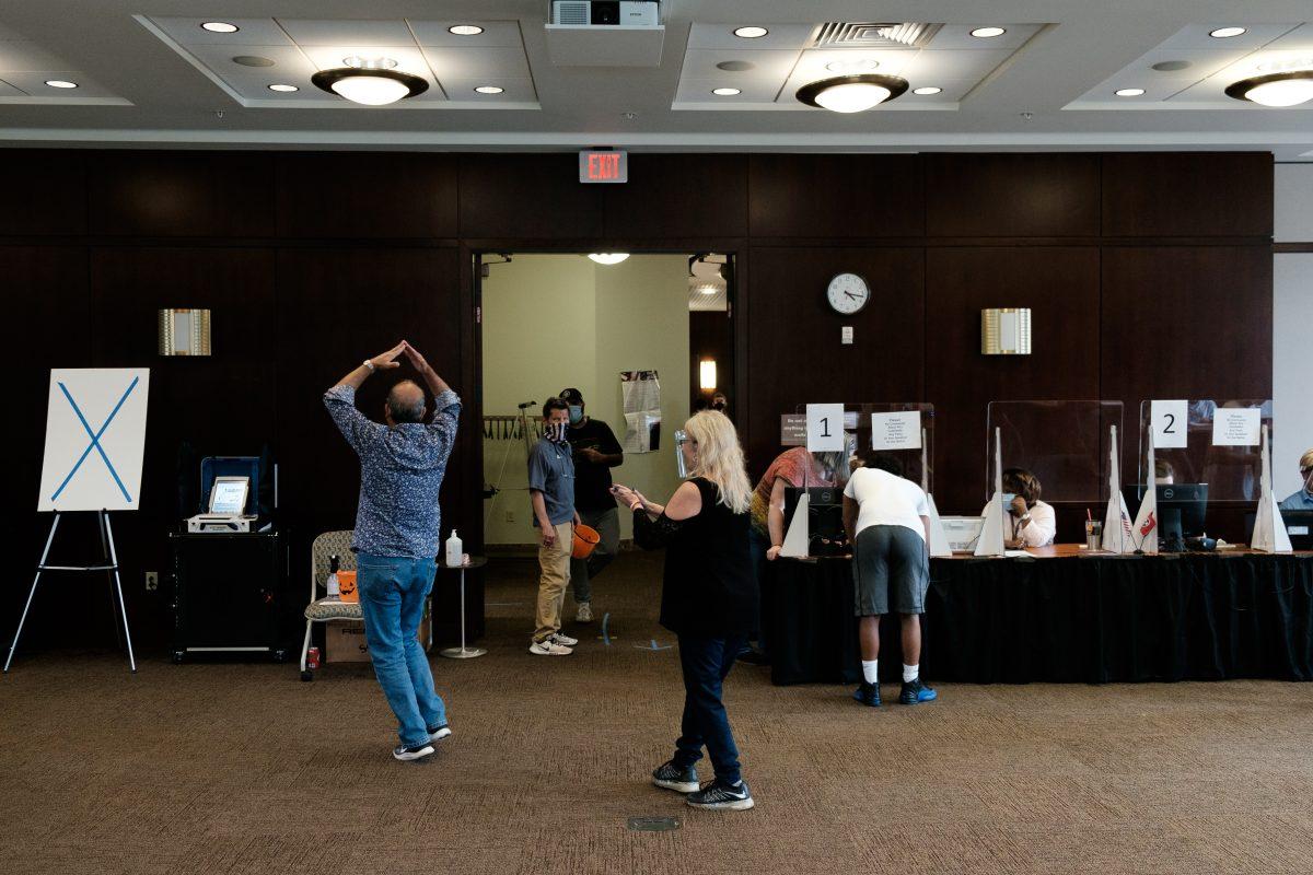 A poll worker does a dance during downtime at Howard Baker Jr. Center on Oct. 26, 2020.