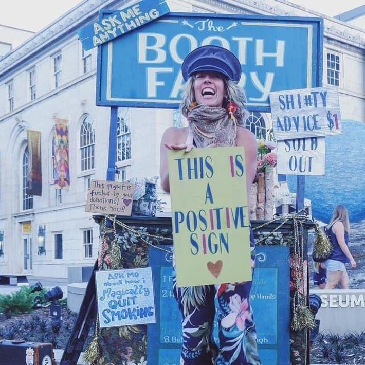 Elle Erickson as the Booth Fairy with various positive signs.