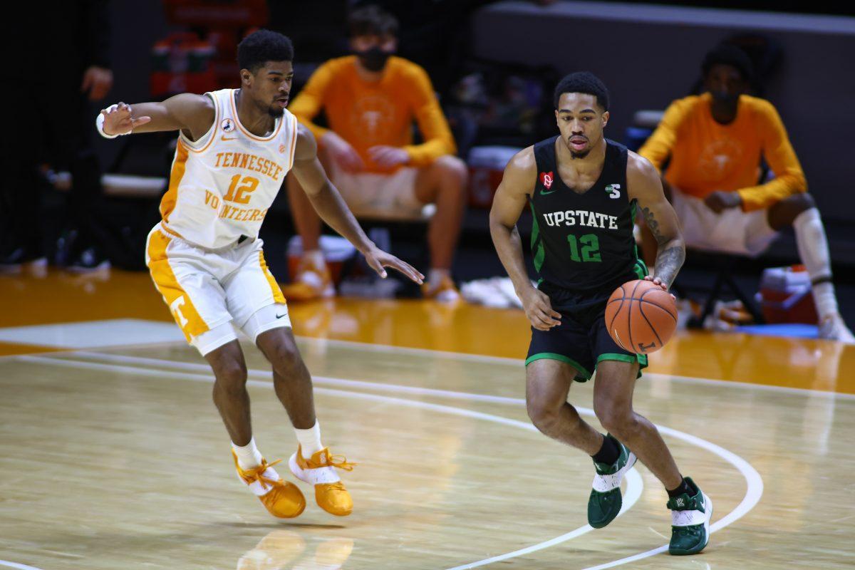 Dec 23, 2020; Knoxville, Tennessee, USA; USC Upstate Spartans guard Everette Hammond (12) moves the ball against Tennessee Volunteers guard Victor Bailey Jr. (12) during the first half at Thompson-Boling Arena. Mandatory Credit: Randy Sartin-USA TODAY Sports