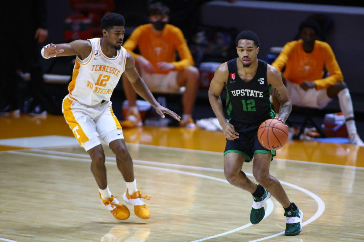 Dec 23, 2020; Knoxville, Tennessee, USA; USC Upstate Spartans guard Everette Hammond (12) moves the ball against Tennessee Volunteers guard Victor Bailey Jr. (12) during the first half at Thompson-Boling Arena. Mandatory Credit: Randy Sartin-USA TODAY Sports