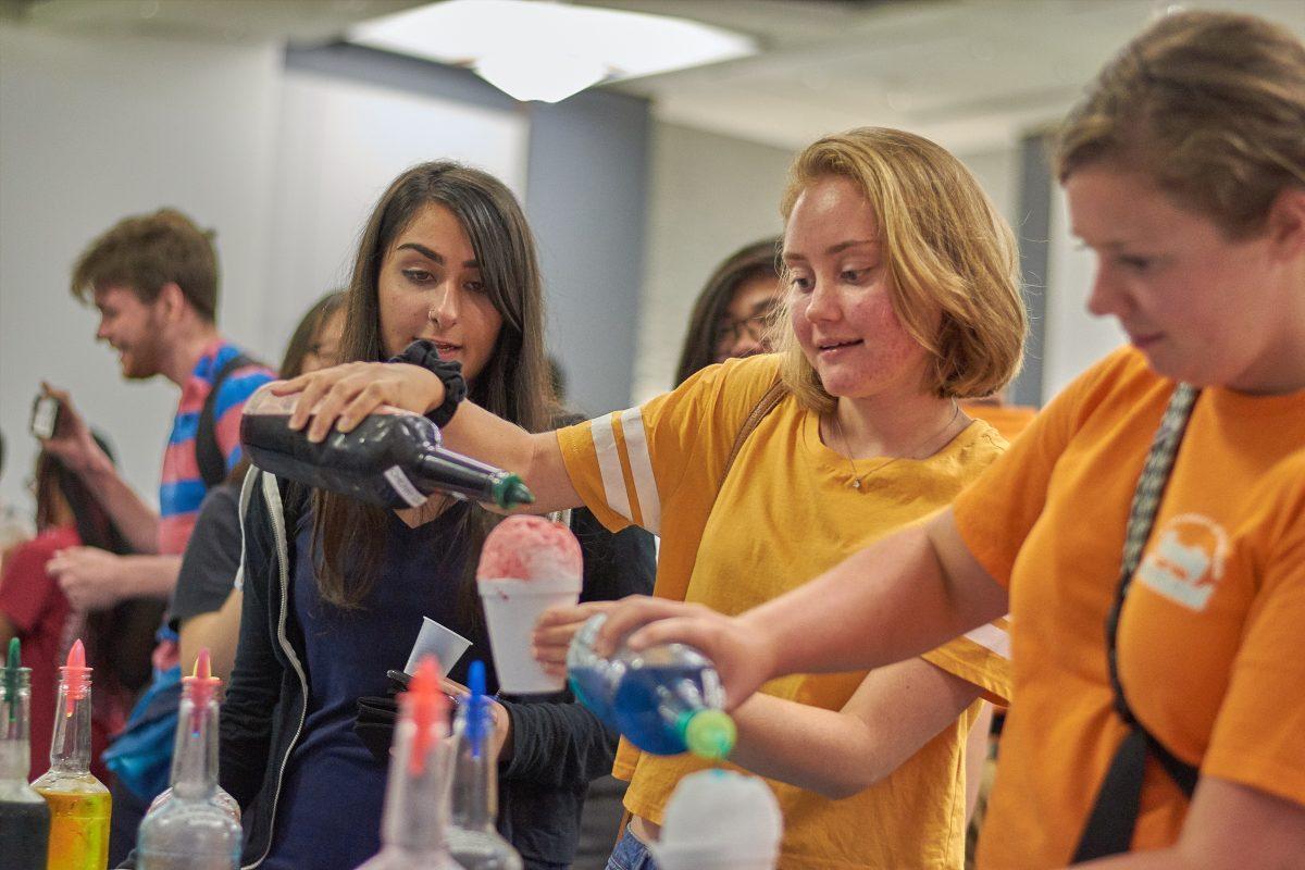 Jennifer Clark pours flavoring onto her snow-cone at the Vol Night Long event, held in the Student Union Ballroom on August 23, 2019.
