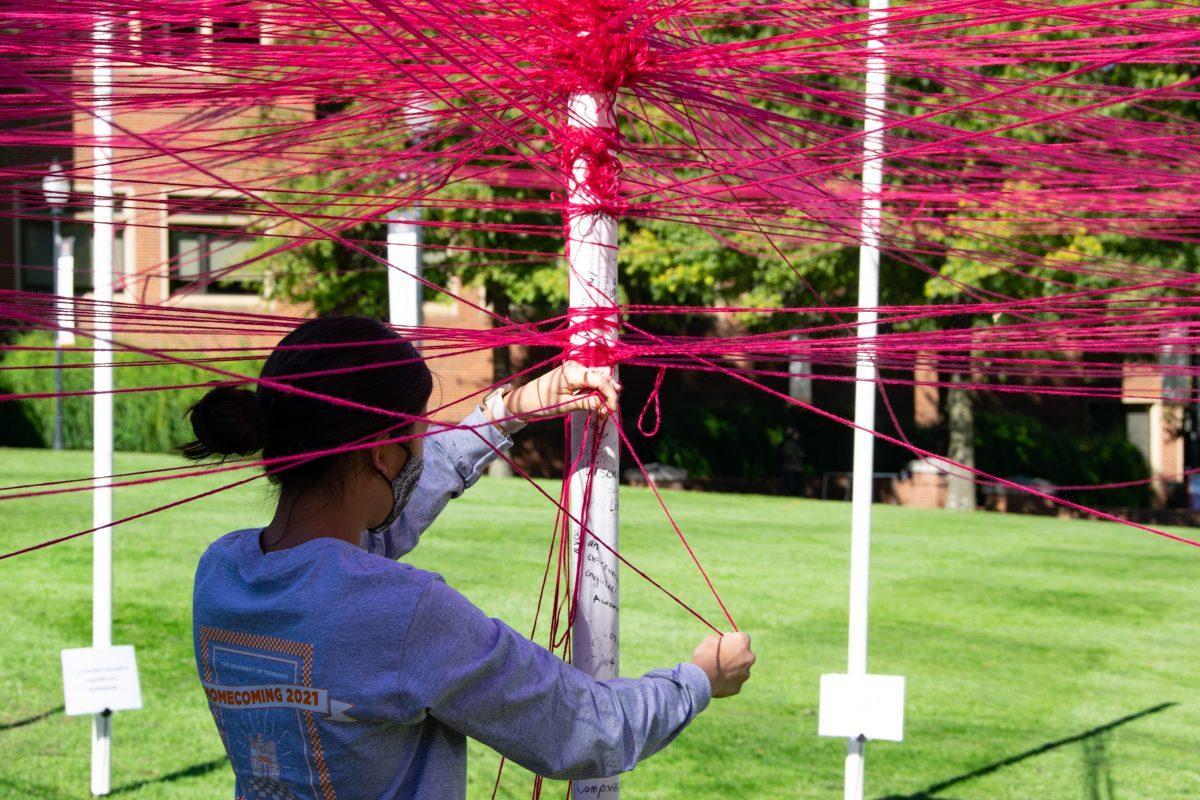 Students weave strings around polls they identify with at The Unity Project event put on by the Student Government Association in HSS Plaza on Wednesday, Oct 27, 2021.