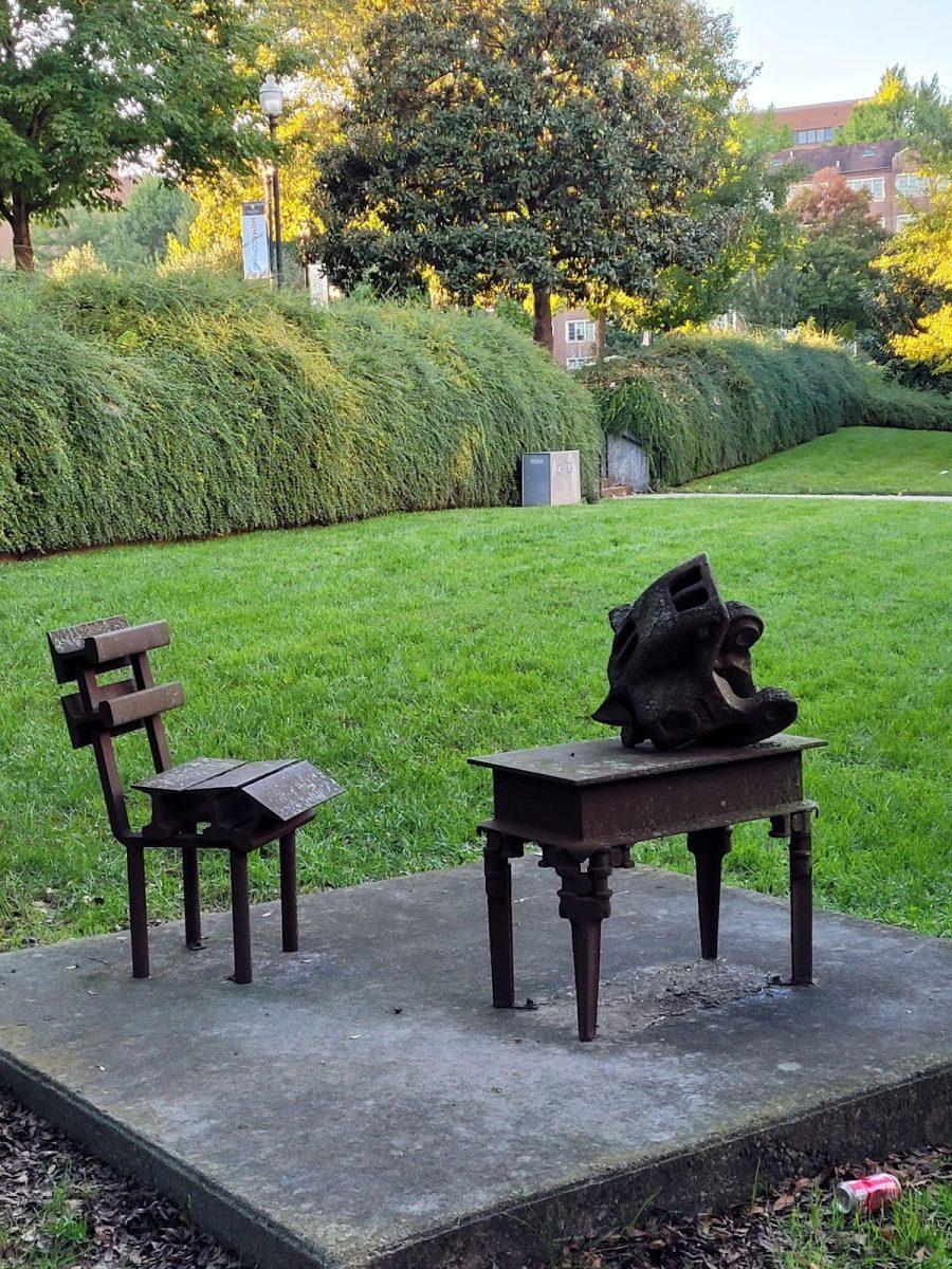 A sculpture of a desk and chair near the Humanities and Social Sciences building. 