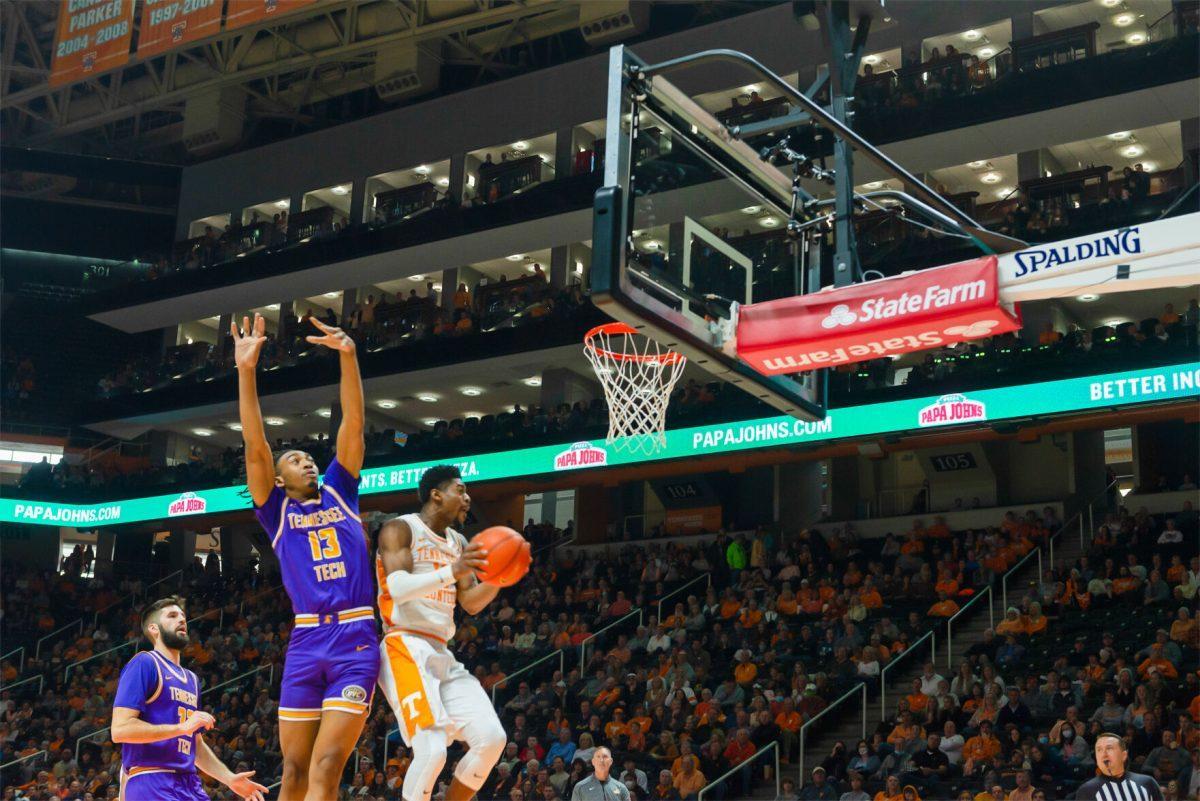 Victor Bailey Jr (12) goes to the rim as Tennessee Tech's Kenny White Jr (13) attempts to block him. At Thompson Boling Arena on Nov. 26, 2021