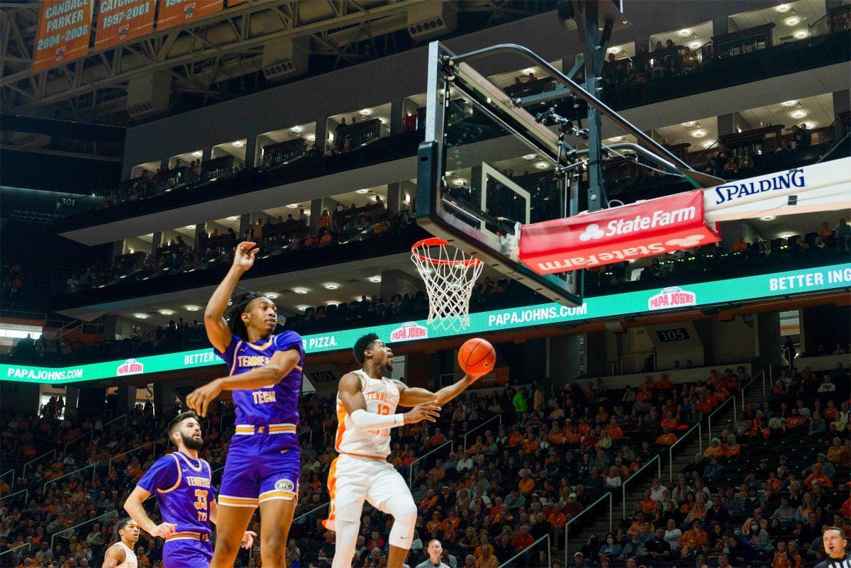 Victor Bailey Jr (12) goes to the rim as Tennessee Tech's Kenny White Jr (13) attempts to block him. At Thompson Boling Arena on Nov. 26, 2021. 