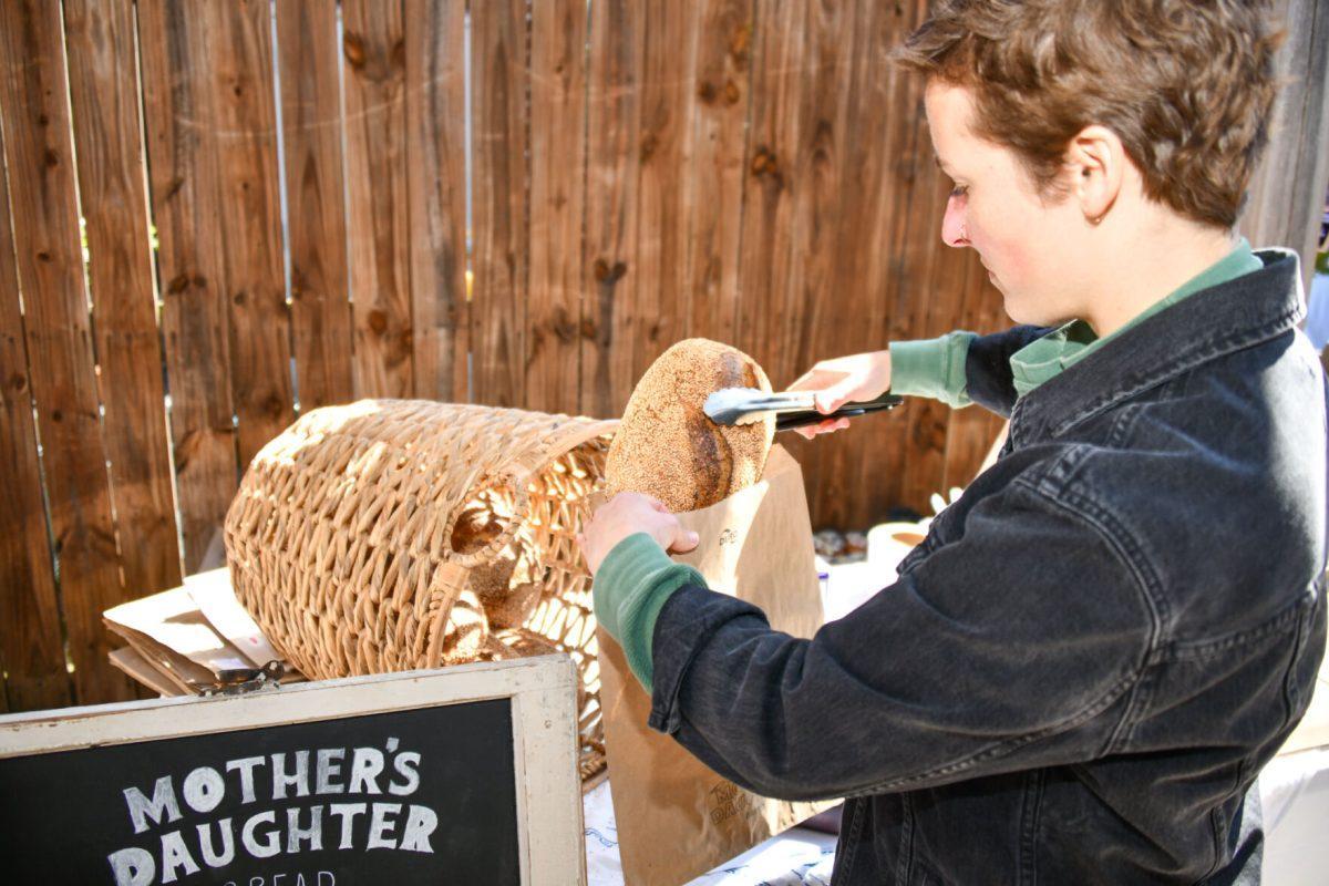 Meade Armstrong, owner of Mother's Daughter Bread, bags a loaf of her sourdough bread. Sunday, Mar. 27, 2022.