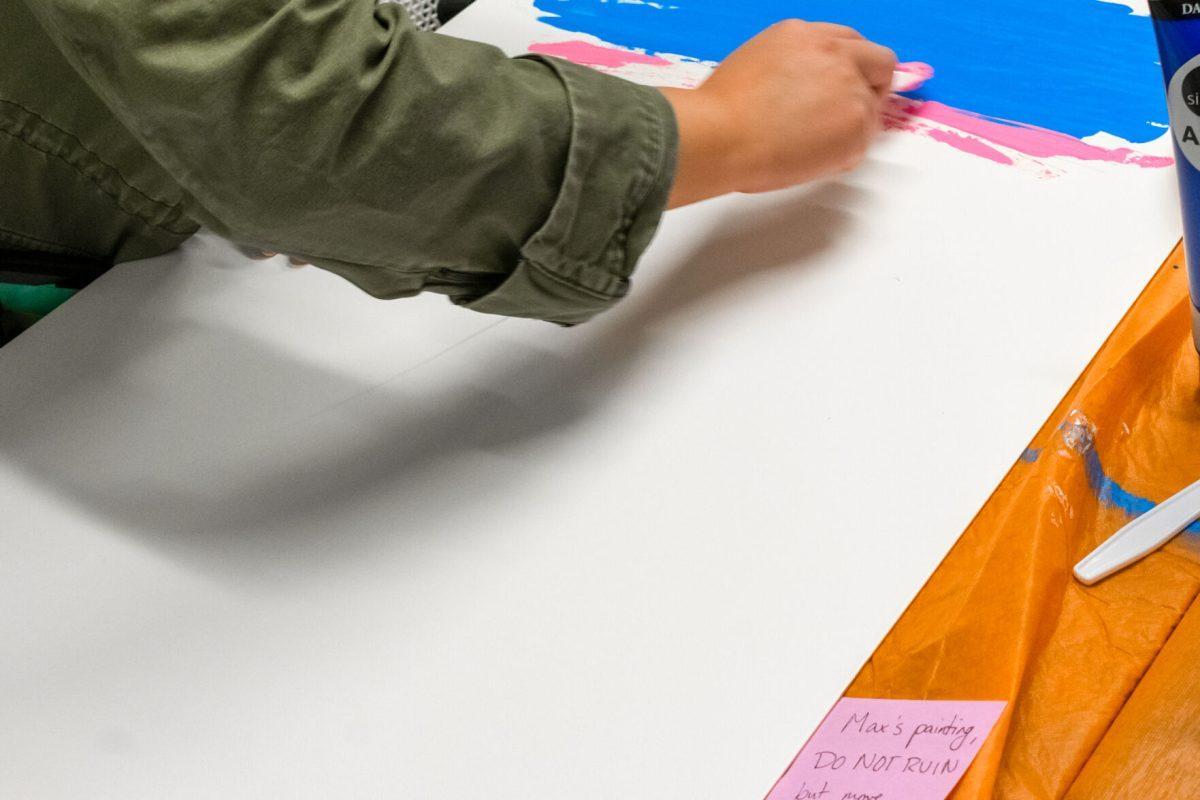 A student creating artwork to be displayed in the Pride Center during the the center's weeklong art project dedicated to celebrating trans joy. Thursday March 31, 2022.
