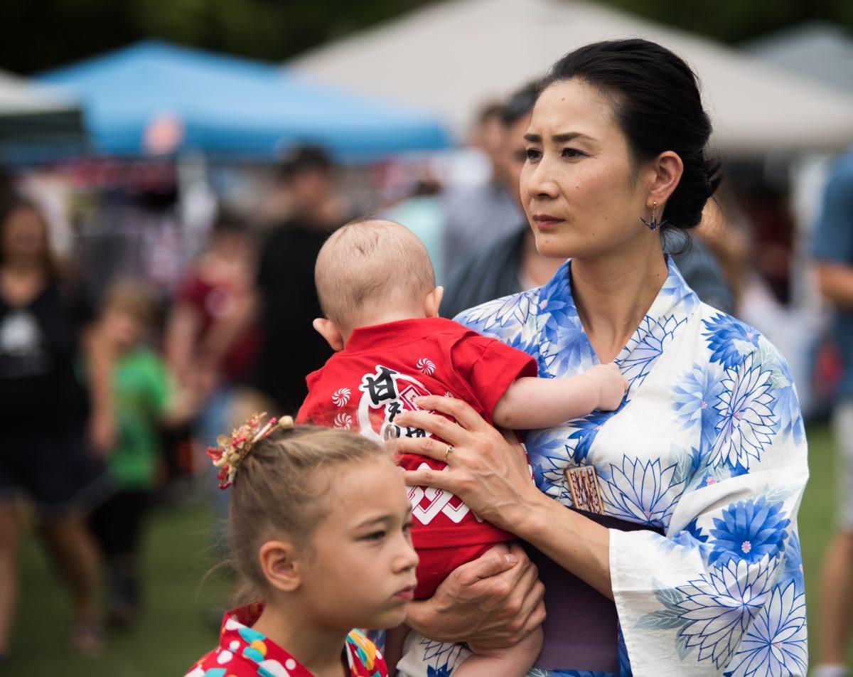 A woman walks with her family in her kimono, a traditional Japanese dress, at the Knoxville Asian Festival at World's Fair Park on August 25, 2019. 