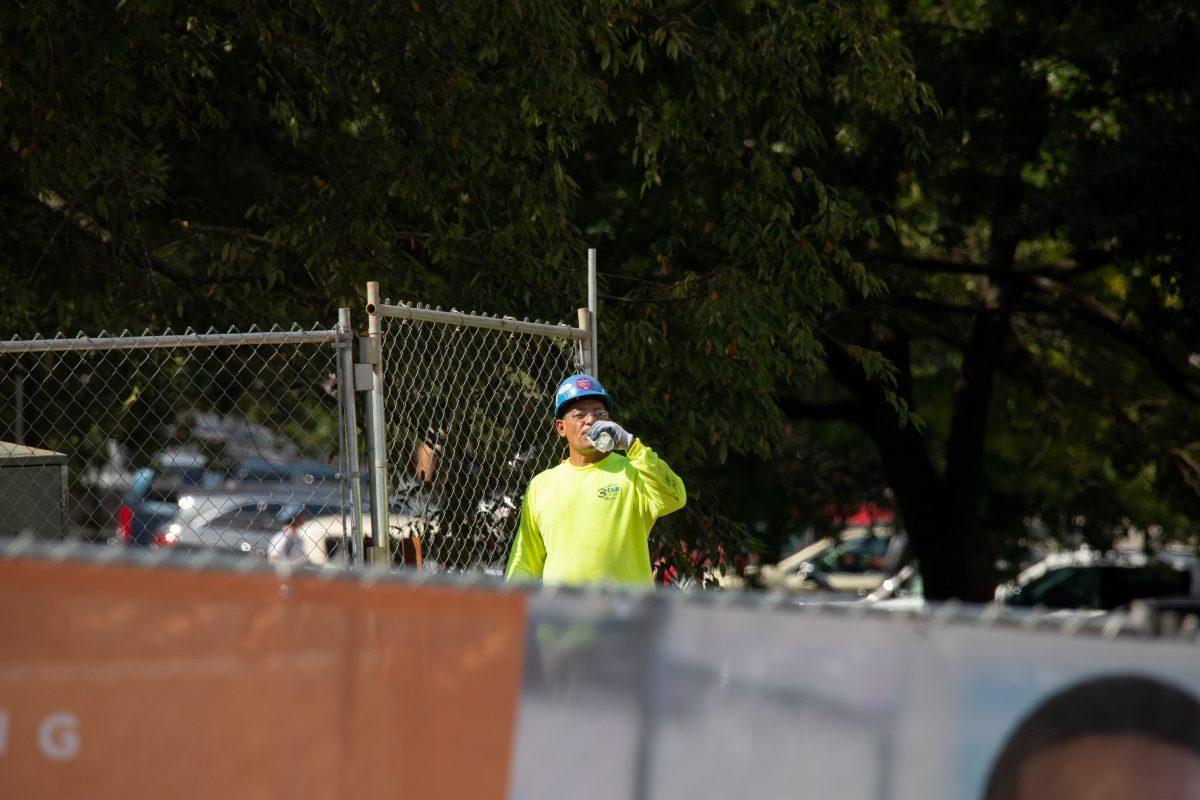 A member of the construction crew takes a break from working on the demolition of the College of Nursing building on Sept. 14, 2022.