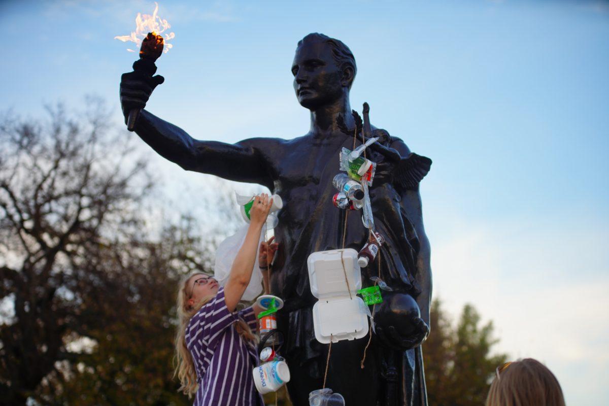KNOXVILLE, TN - Plastic Free UT co-founder Rachel Stewart blouses the UT Torchbearer with plastic containers in protest of single use plastics on campus for International Day of Climate Action. Monday, Oct. 24, 2022. 