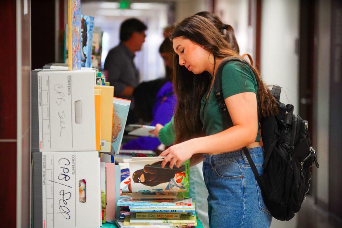 Students browse the through the Fall Book Sale hosted by the Center for Children’s and Young Adult Literature in the Claxton Education Building on Nov. 2, 2022.