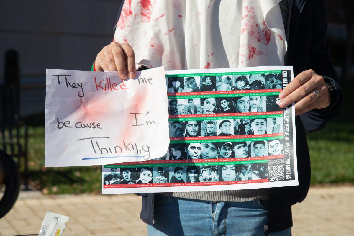 Signs held by rallying students and residents on Ped Walkway showed dozens of children killed by Iranian government forces in response to anti-regime uprisings. 