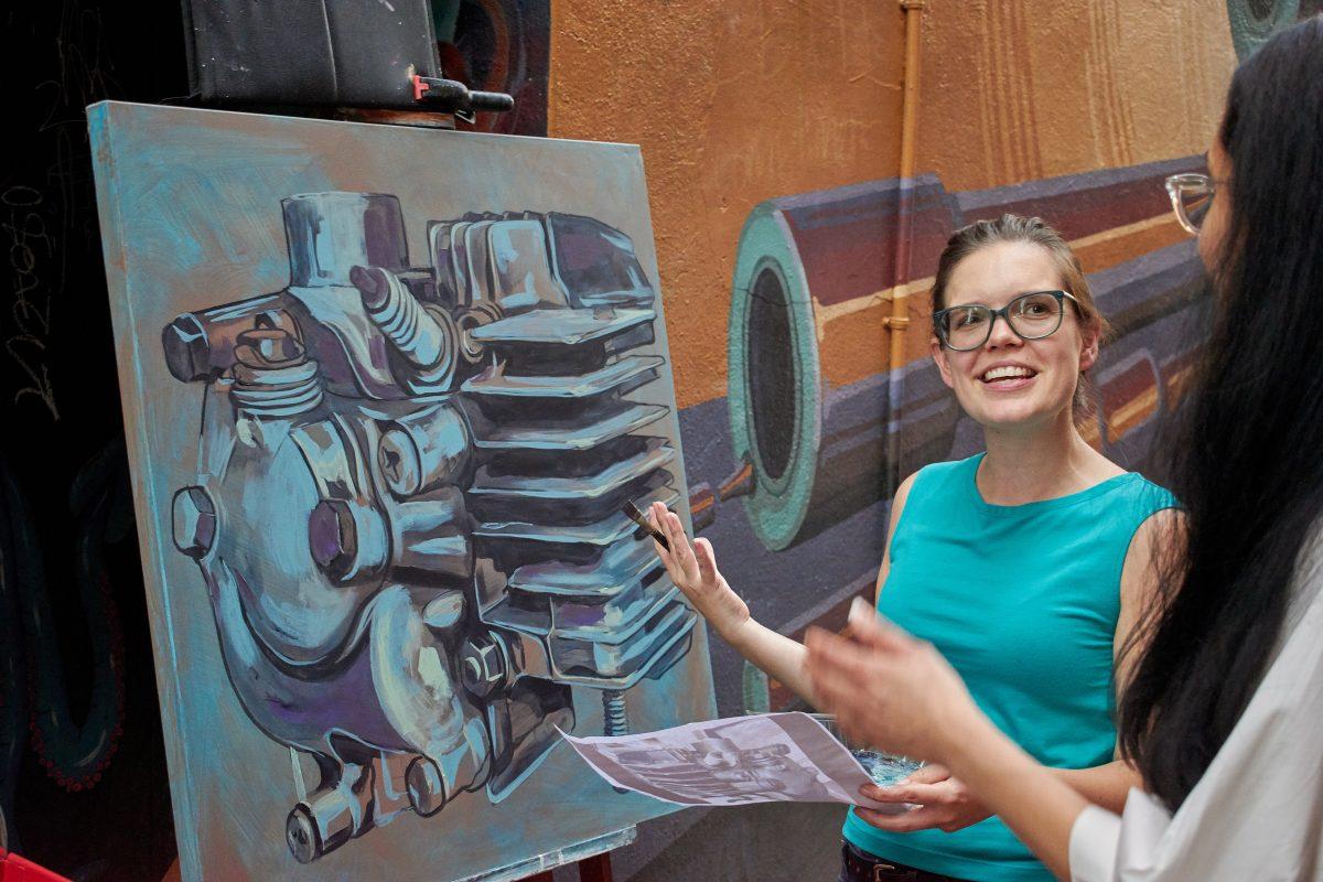 Megan Lingerfelt discusses her artwork with a passerby at the Art Slam event in the Strong Graffiti Alley in Downtown Knoxville on September 6, 2019. 