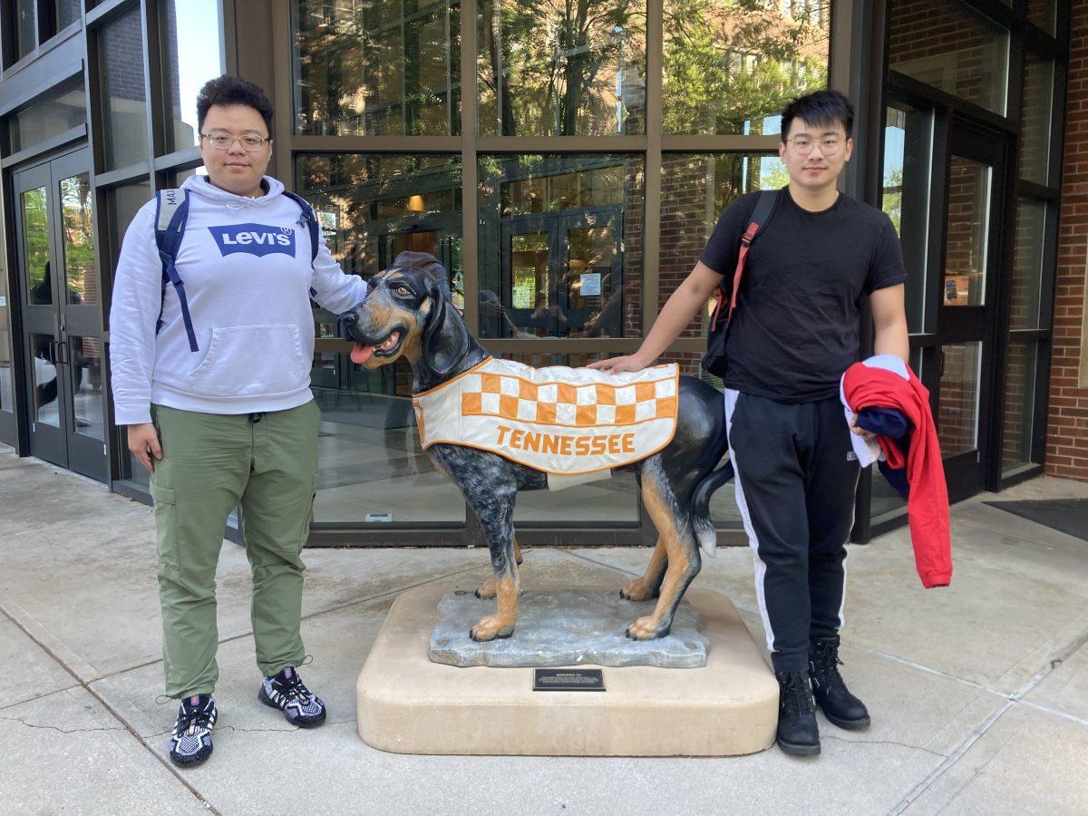 Jinning Wang (left), a third year doctoral student in electrical engineering, and Gao Chang (right), a junior studying music performance, stand outside Hodges Library.