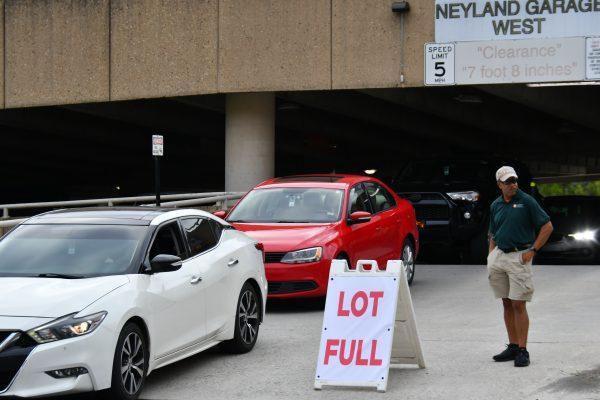 An employee from UT Parking and Transportation Services stands outside a full G10 parking garage, directing commuters to possible alternatives around campus. Wednesday, Aug. 30, 2023.