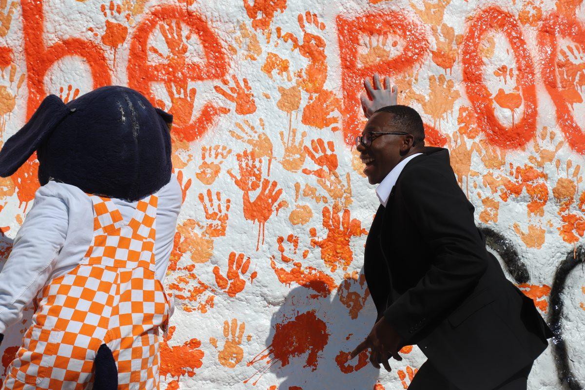 Smokey joins the SGA and puts him paw print on the rock with other students' handprints. 
