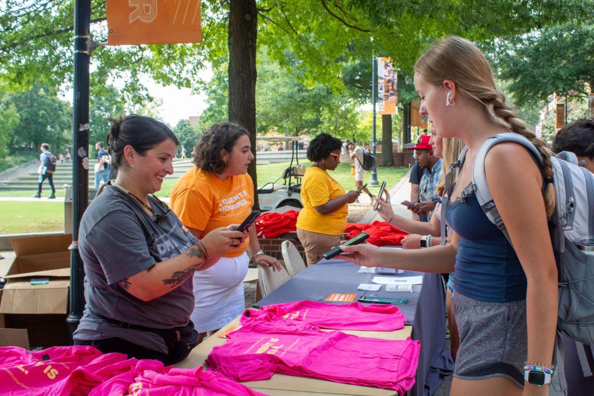 A Center for Health Education &amp; Wellness representative scans a student's event pass in order to give her a 'consent is mutual' t-shirt on Sept. 5, 2023.