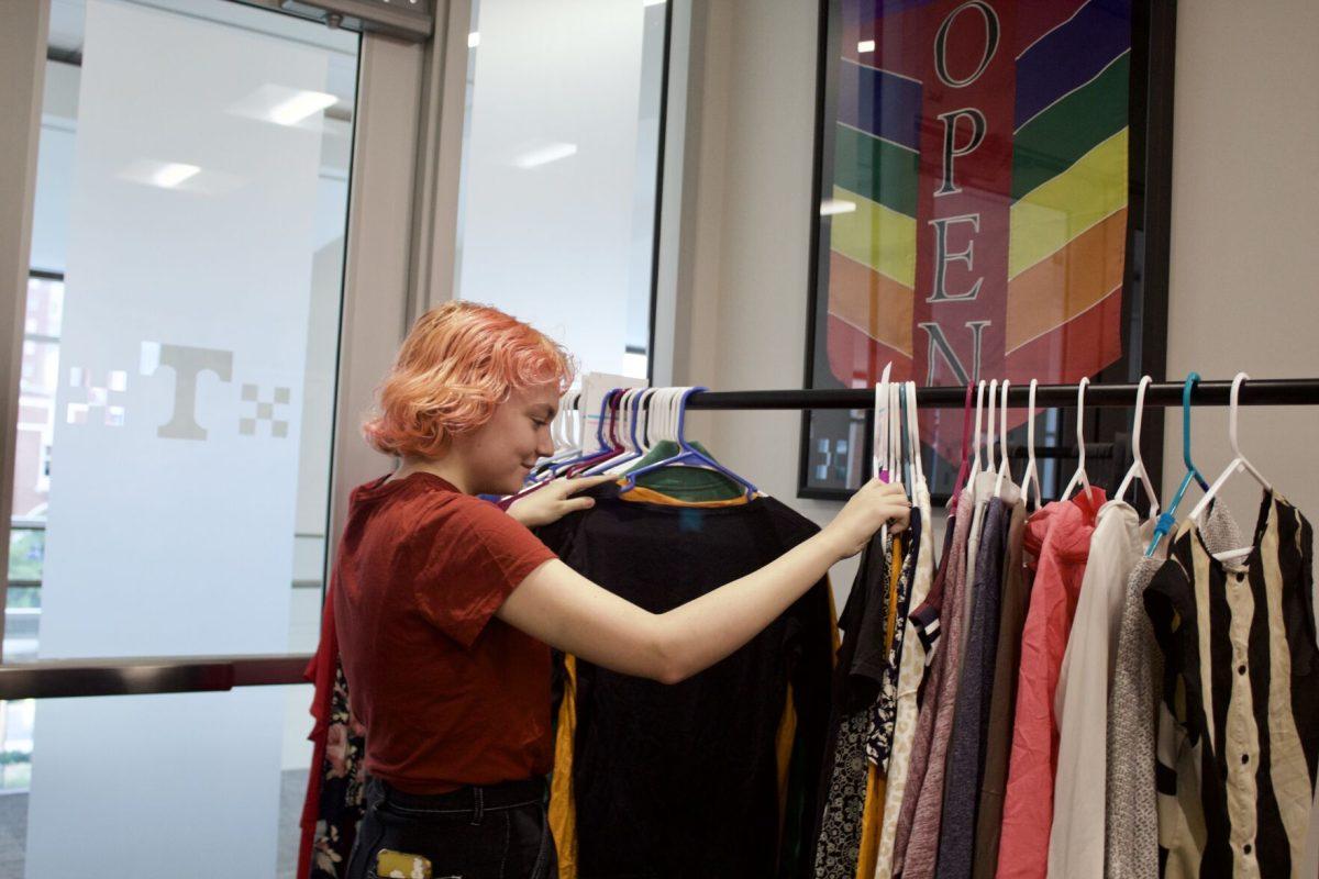 Zoe Trainor, a junior majoring in english, sorts through a rack of clothing at the Pride Center's Qloset Pop-up on Oct. 11, 2023.