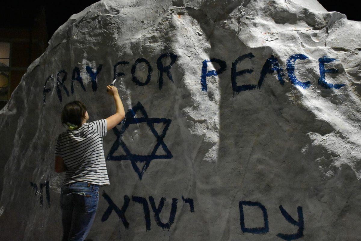 A student paints the Rock in memoriam of those who were killed in the Hamas attack. Thursday, Oct. 12, 2023.