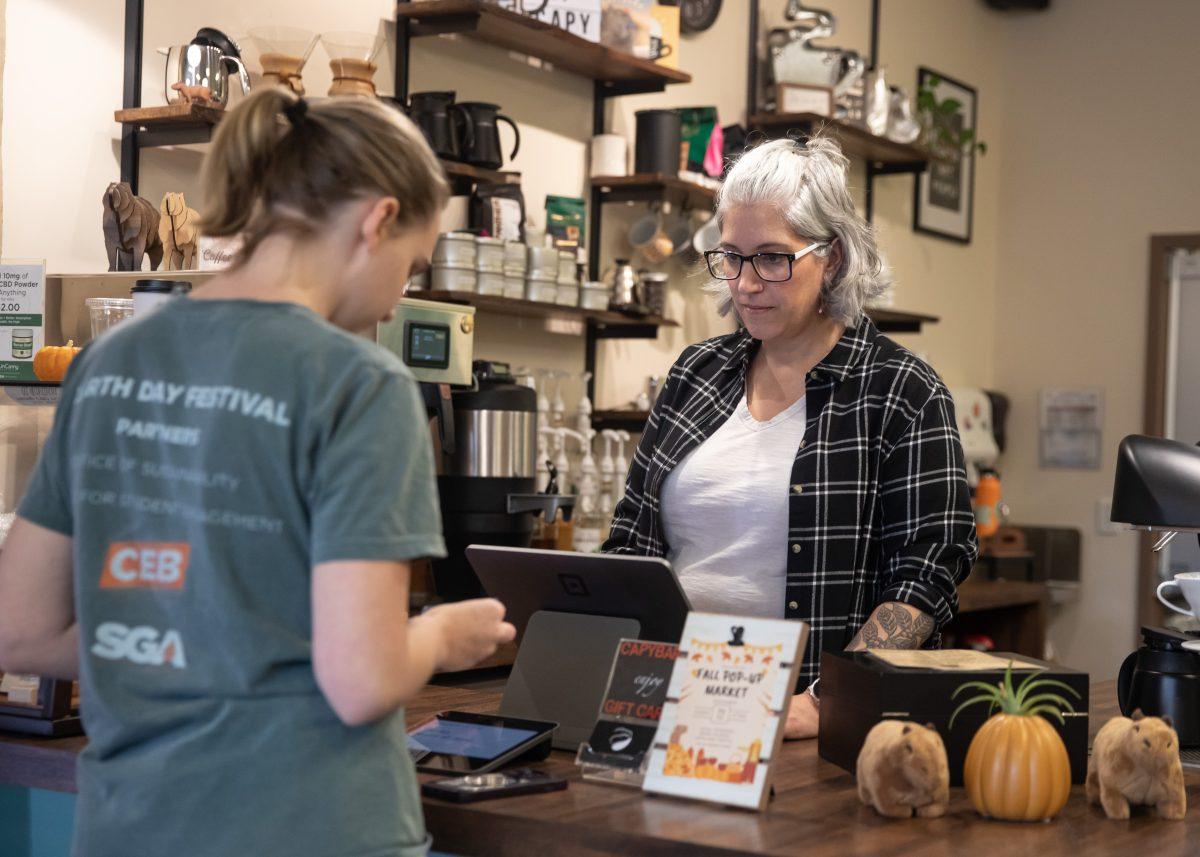 Leticia Fernandes, owner of Capybara Coffee, assists customers at her shop. Wednesday, Nov. 15, 2023.