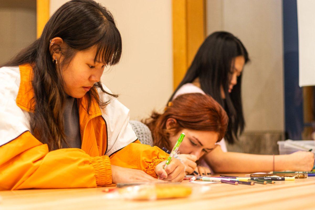 Senior Annie Powers (left) and her friends plan out their bracelets at the Hodges Library Makerspace open house on Nov. 3, 2023.