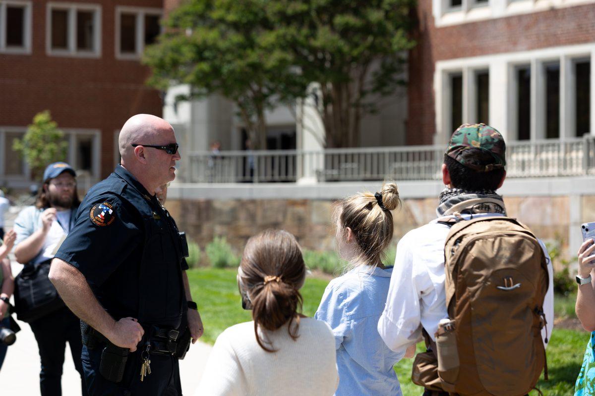 A police officer speaks with pro-Palestinian demonstrators in front of the UT College of Law. Thursday, May 2, 2024. 