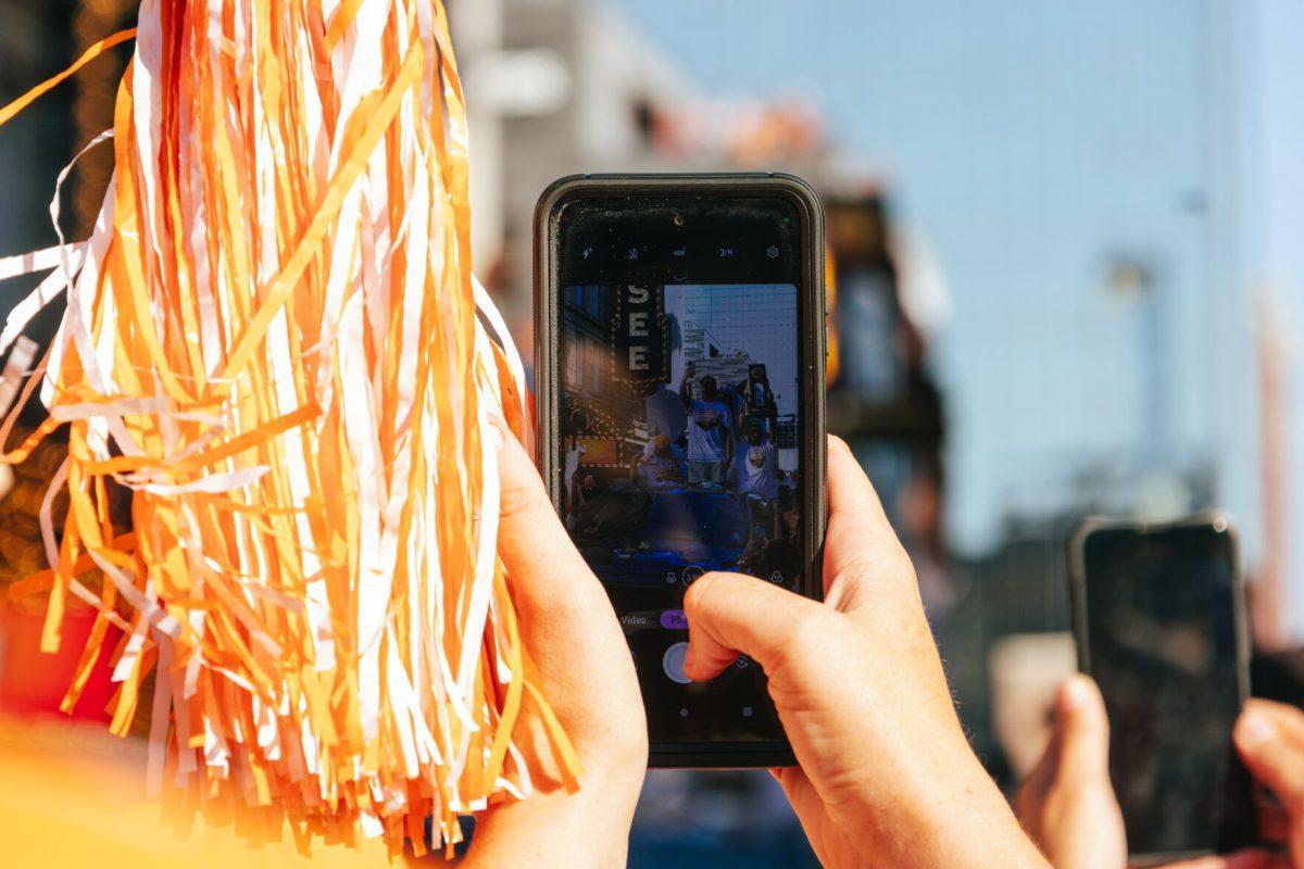 Volunteer Fan takes a photo during the National Champion Volunteers parade. Tuesday, June 25, 2024.