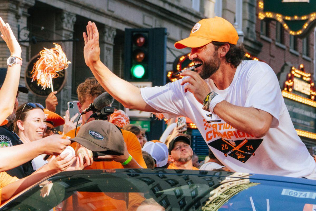 Tony Vitello celebrates with fans during the National Champion Volunteers parade. Tuesday, June 25, 2024. 