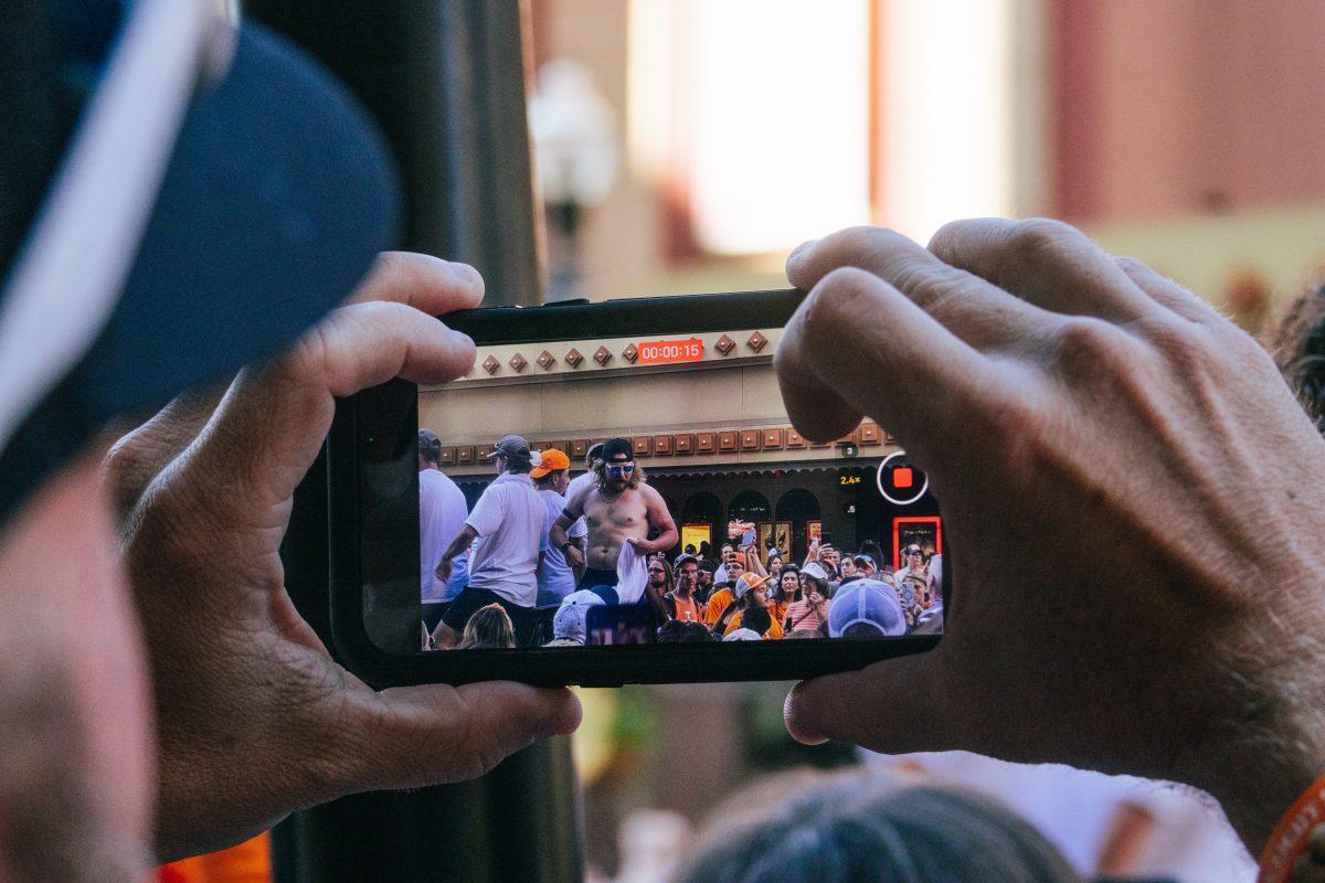 Volunteer Fan takes a video during the National Champion Volunteers parade. Tuesday, June 25, 2024.