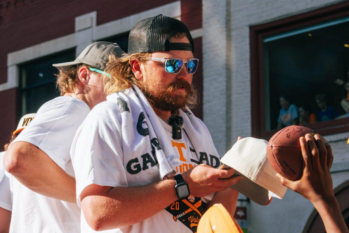 Kirby Connell (35) signs autographs during the National Champion Volunteers parade. Tuesday, June 25, 2024.