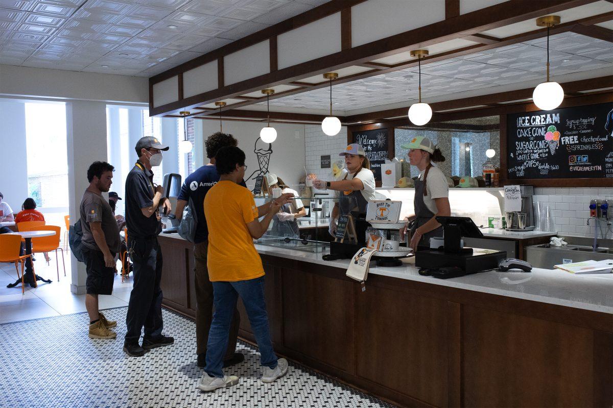 Ellie Ackermann (center) serves ice cream at the UT creamery as Kate Cattani (right) looks on. Friday Aug. 16, 2024. 