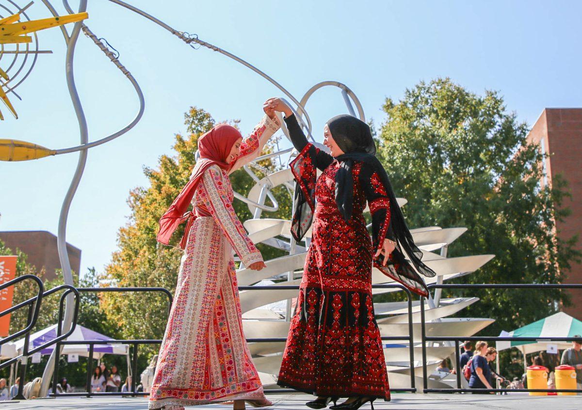 Two students from the Students for Justice in Palestine organization show off traditional female Palestinian attire at the International Festival on the Pedestrian Walkway. Friday, Oct. 25, 2024.