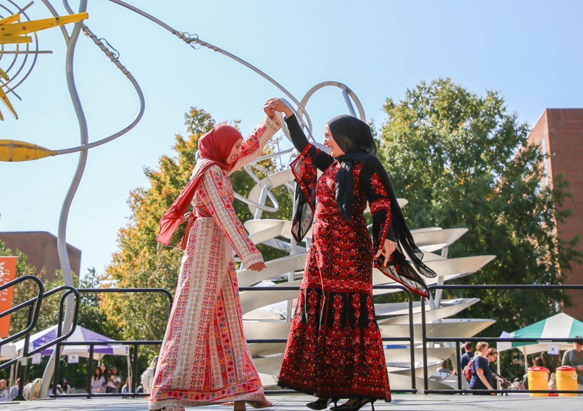 Two students from the Students for Justice in Palestine organization show off traditional female Palestinian attire at the International Festival on the Pedestrian Walkway. Friday, Oct. 25, 2024.