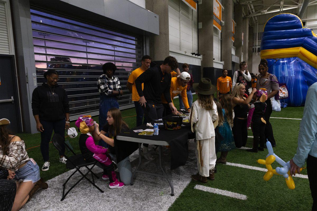 Members of the track and field team run a face painting and craft station during Voloween at Neyland Thompson Indoor Field. Monday, Oct. 28, 2024.