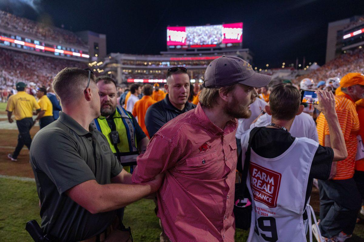 A fan is arrested after pushing Tennessee football players at Donald W. Reynolds Razorback Stadium. Saturday, Oct. 5, 2024. 