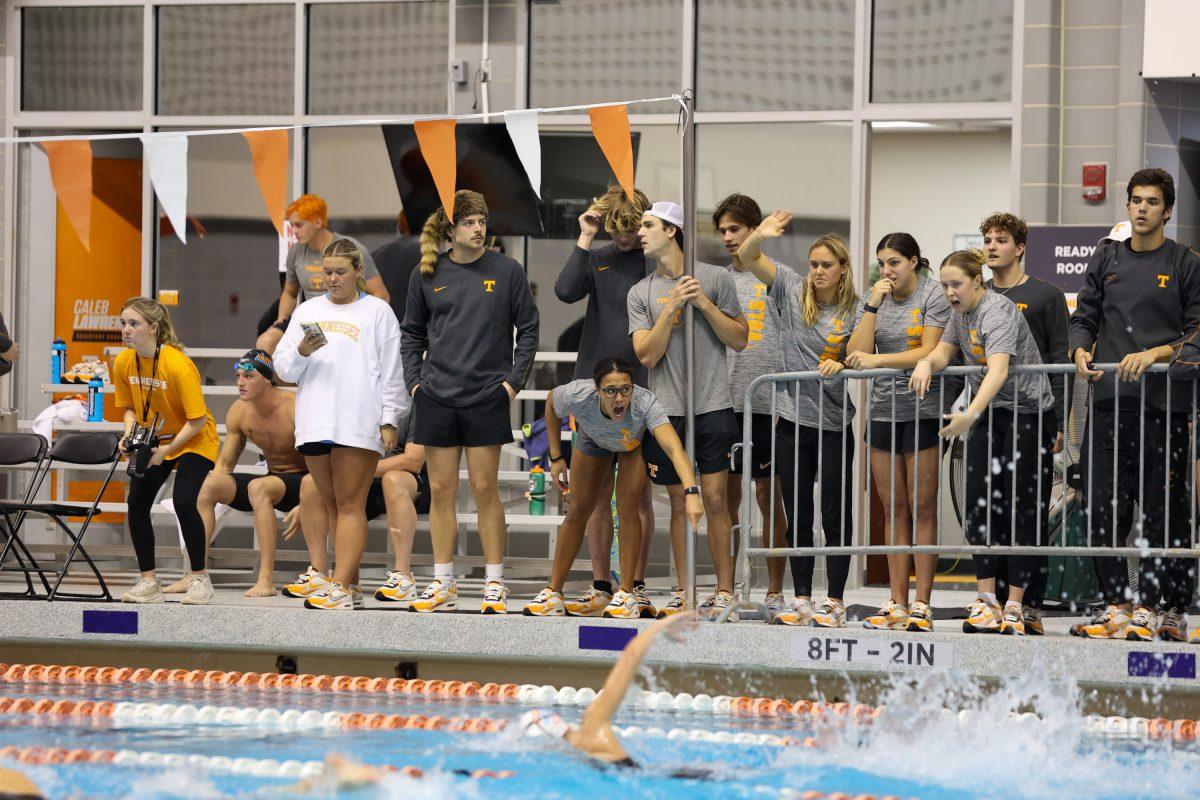 Teammates cheer on players in relay race against the University of Kentucky at Allen Jones Aquatic Center. November 19, 2024.