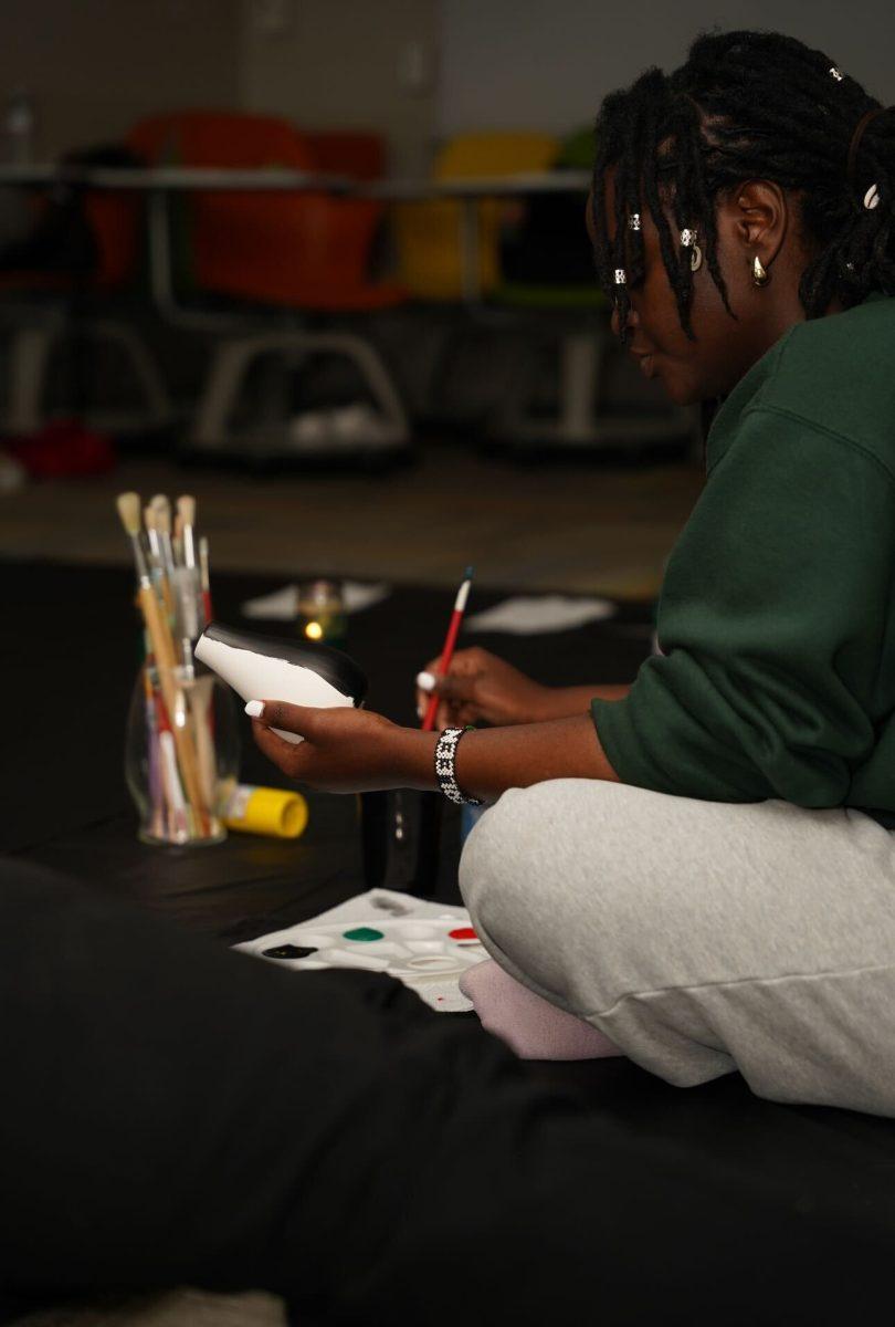 Sherleen Mwaura paints a vase during Black Students for Artistic Expression's art therapy event. Thursday, Aril 10, 2025.