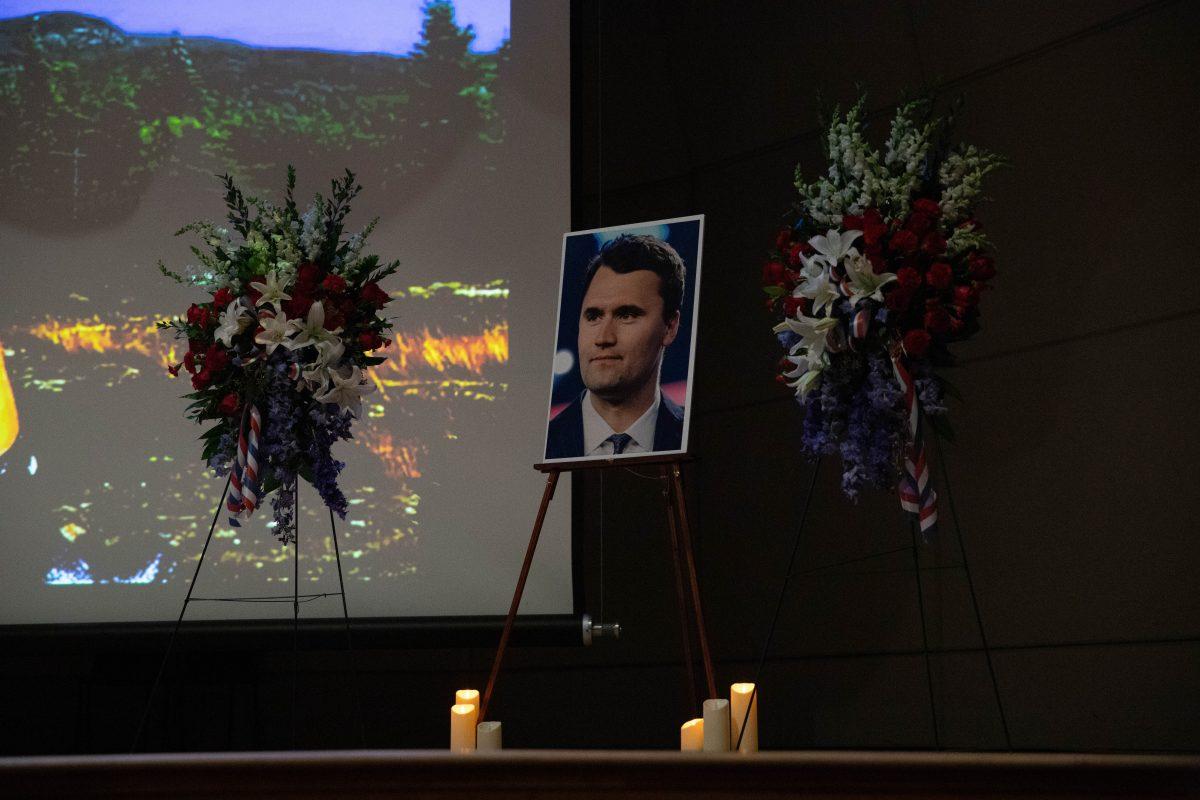 Charlie Kirk's photo on stage, surrounded by wreaths, at TPUSA's Sept. 17 remembrance. 