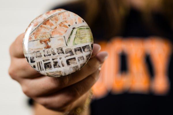 Freshman Sydney Larson holds a button she produces and sells as a dorm side hustle with Hailey Story, Issabella Martinez and Kara McKinley.