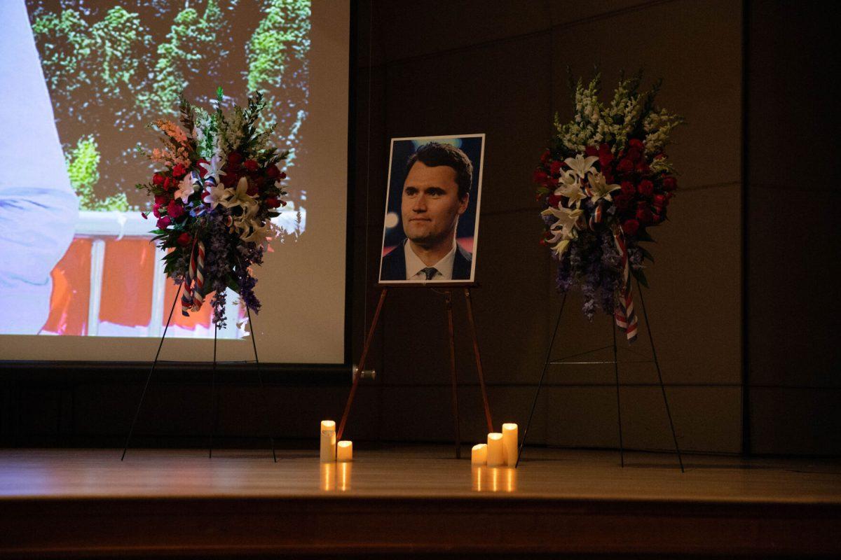 Charlie Kirk's photo on stage, surrounded by wreaths, at TPUSA's Sept. 17 remembrance. 