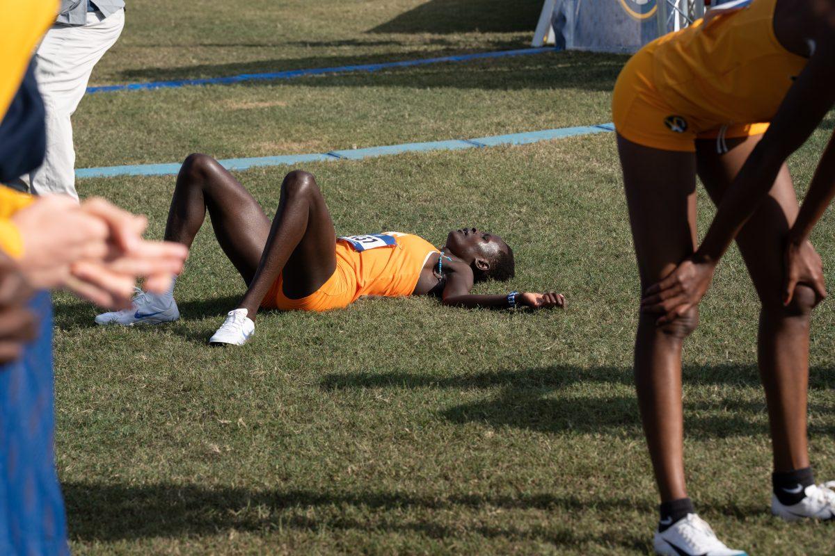 Tennessee's Mary Ogwoka lies down in exhaustion after finishing the Women's SEC Cross Country Championship race at Cherokee Farms. Friday, Oct. 31, 2025.