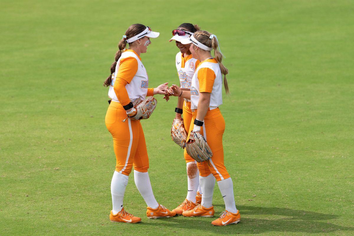 (from left) Gabby Leach (55), Saviya Morgan (20), and Sophia Knight (2) gather in the outfield for a pre-inning ritual. Saturday, Sept. 27, 2025.