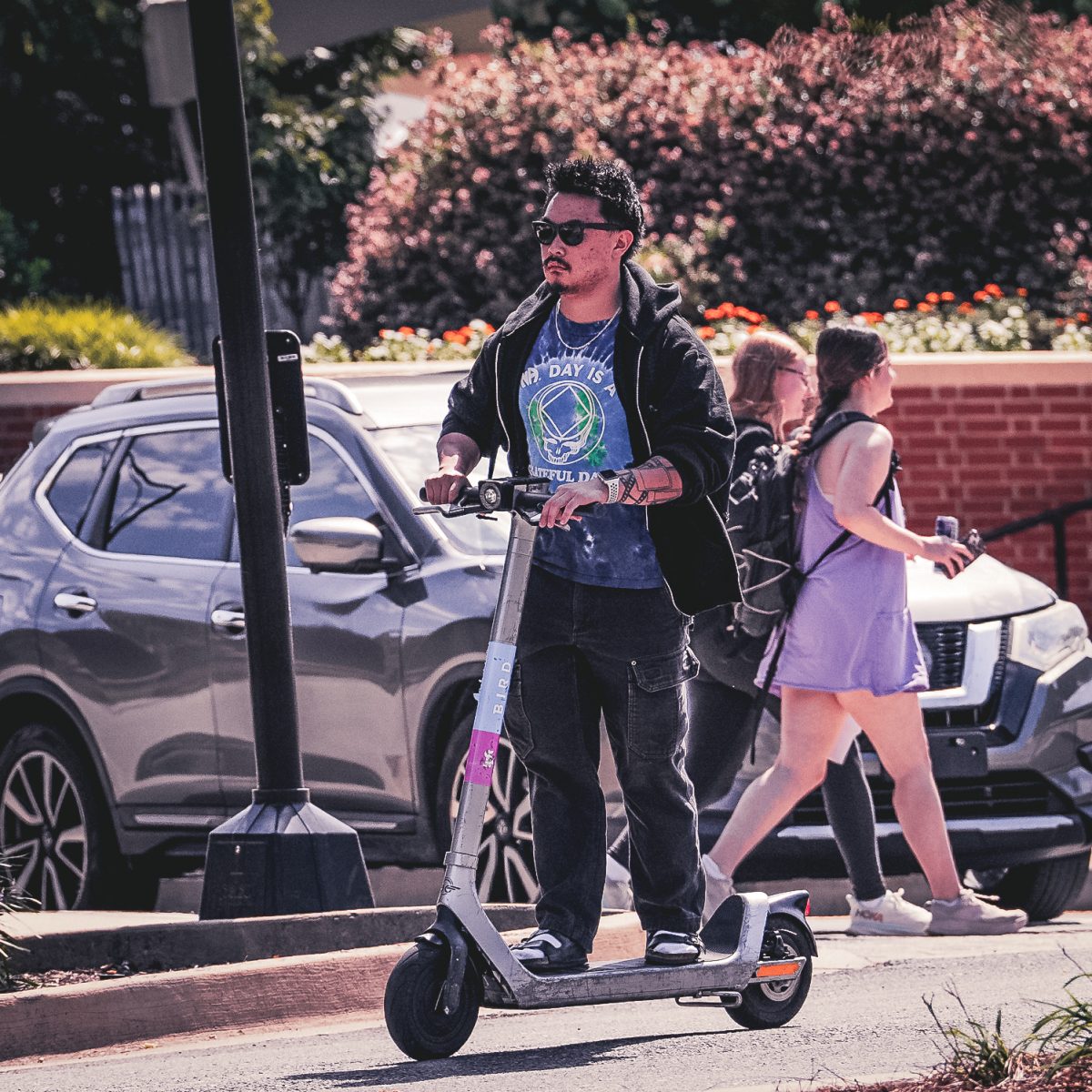 A student rides a scooter on campus by Circle Park. Sept. 8, 2025.