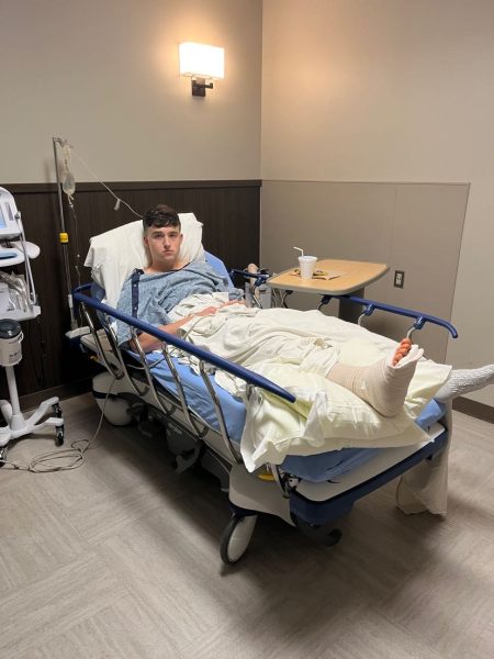 Calvin Wetzel lays in a hospital bed after receiving foot surgery.