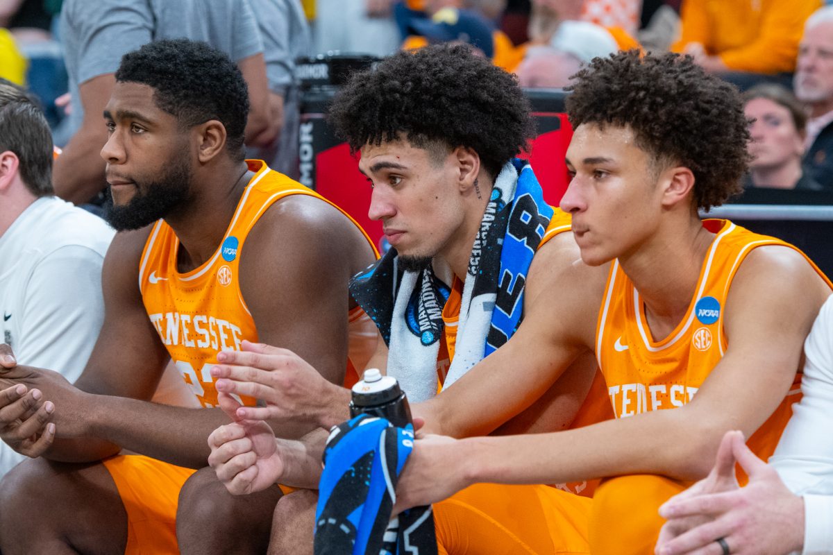 Jaylen Carey (23), Bishop Boswell (3) and Nate Ament (10) sit on the bench during an NCAA Tournament game against Michigan at United Center. Sunday, March 29, 2026.