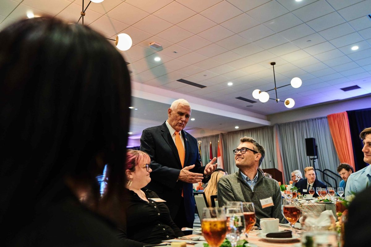 Former Vice President Mike Pence addressing a table of attendees.